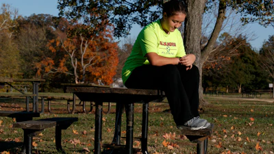 Grace Brown, 14, adjusts her fitness tracker at the park where she does her jogging workouts for her 'online PE' class, Alexandria, Va., Nov. 1, 2019.
