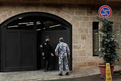 A private security guard speaks with a policeman at the residence of former Nissan Chairman Carlos Ghosn, Dec. 31, 2019, in Beirut.