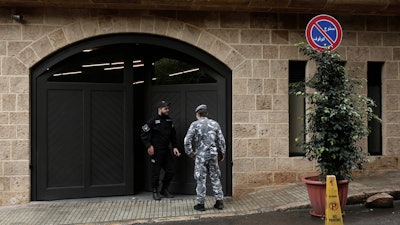 A private security guard speaks with a policeman at the residence of former Nissan Chairman Carlos Ghosn, Dec. 31, 2019, in Beirut.