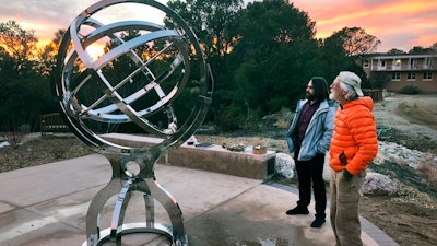 In this Dec. 11, 2019, photo Bill Donahue, right, a retired teacher and director of laboratories at St. John's College, and student Devin Ketch use an armillary sphere to track planetary rotations in Santa Fe, N.M.