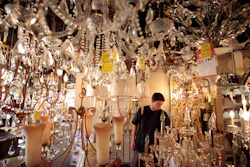 In this Jan. 21, 2011, file photo, Jack George, an employee at Royal Lighting, looks at chandeliers using incandescent light bulbs at the store in Los Angeles.