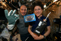 In this photo made available by U.S. astronaut Christina Koch via Twitter on Dec. 26, 2019, she and Italian astronaut Luca Parmitano pose for a photo with a cookie baked on the International Space Station.