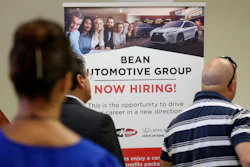 In this Sept. 18, 2019, file photo, people stand in line to inquire about jobs available at the Bean Automotive Group during a job fair in Miami.