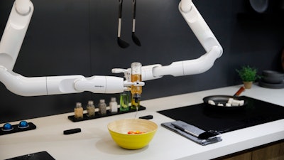 The Bot Chef pours dressing into a salad during a demonstration at the Samsung booth during the CES tech show, Jan. 7, 2020, in Las Vegas.