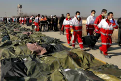Rescue workers carry the body of a victim of a plane crash in Shahedshahr, Iran, Jan. 8, 2020.