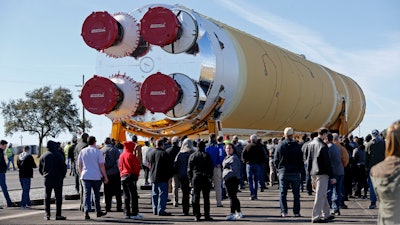 Employees and contractors watch as the core stage of NASA's Space Launch System rocket is moved to the Pegasus barge at the NASA Michoud Assembly Facility, New Orleans, Jan. 8, 2020.