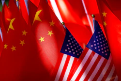 In this Sept. 16, 2018, file photo, American flags are displayed together with Chinese flags on top of a trishaw in Beijing.