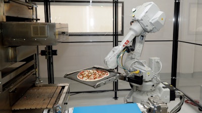 In this Aug. 29, 2016, file photo, a robot places a pizza into an oven at Zume Pizza in Mountain View, Calif.