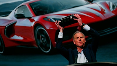 Tadge Juechter, Corvette executive chief engineer, holds up the trophy after the new mid-engine Corvette was named the North American Car of the Year in Detroit, Jan. 13, 2020.