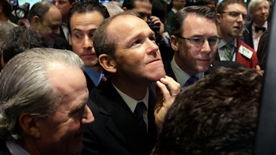 In this Jan. 26, 2011, file photo, Nielsen Company CEO David Calhoun, center, watches progress as he waits for the company's IPO to begin trading on the floor of the New York Stock Exchange.