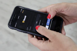 In this May 29, 2019, file photo, a woman checks the Grindr app on her mobile phone in Beirut, Lebanon.