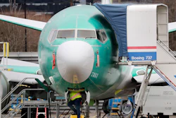 In this Dec. 16, 2019, file photo, a worker looks up underneath a Boeing 737 Max jet, Renton, Wash.