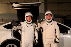 In this Jan. 17, 2020, photo, astronauts Doug Hurley, left, and Robert Behnken pose in front of a Tesla Model X at a SpaceX launch dress rehearsal at Kennedy Space Center in Florida.