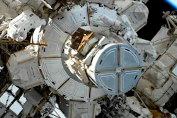 In this image take from NASA video, astronaut Christina Koch, left, moves away as Jessica Meir, right, exits a hatch as they prepare to install batteries for the International Space Station's solar power grid, Jan. 20, 2020.