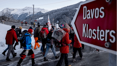 Hundreds of climate protesters who are on a three-day protest march from Landquart to Davos pass the city of Klosters, Switzerland, Jan. 20, 2020.