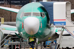 In this Dec. 16, 2019, file photo, a worker looks up underneath a Boeing 737 Max jet in Renton, Wash.