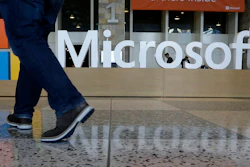 In this April 28, 2015, file photo, a man walks past a Microsoft sign at Moscone Center in San Francisco.