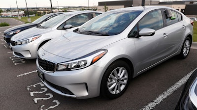 In this June 26, 2018, file photo, a used 2017 Kia Forte sits in a row of other used, late-model sedans at a dealership in Centennial, Colo.