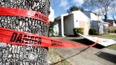 Red 'danger' tape circles a damaged home on Bridgeland Lane in Houston, Jan. 26, 2020.