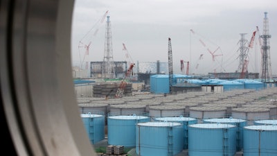 In this Feb. 23, 2017, file photo, storage tanks for contaminated water are seen through a window of a building at the Fukushima Dai-ichi nuclear power plant, Okuma town, Japan.