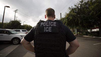 In this July 8, 2019, photo, a U.S. Immigration and Customs Enforcement officer looks on during an operation in Escondido, Calif.