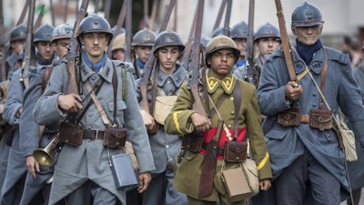 Men dressed in World War I uniforms march during a parade, part of a reconstruction of the Battle of Verdun, Aug. 25, 2018, in Verdun, France.