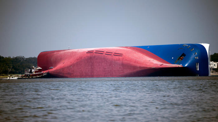 In this Sept. 9, 2019, file photo, a Moran tugboat nears the stern of the capsizing vessel Golden Ray near St. Simons Sound off the coast of Georgia.