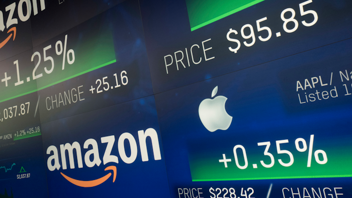 In this Sept. 4, 2018, file photo, Amazon and Apple stock prices are shown on an electronic screen at the Nasdaq MarketSite in New York.