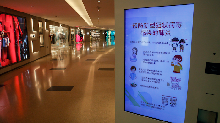 In this Feb. 9, 2020, file photo, an electronic display board shows a precautionary notice of the coronavirus at a deserted upscale shopping mall in Beijing.