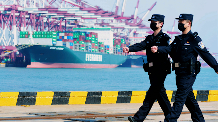 Police officers wearing face masks patrol at a container port in Qingdao, China, Feb. 19, 2020.