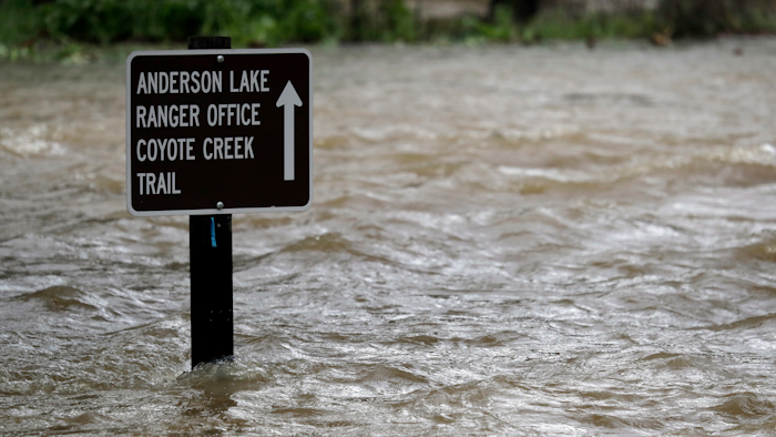 Sign is submerged in water from Coyote Creek, Morgan Hill, Calif., Feb. 21, 2017.