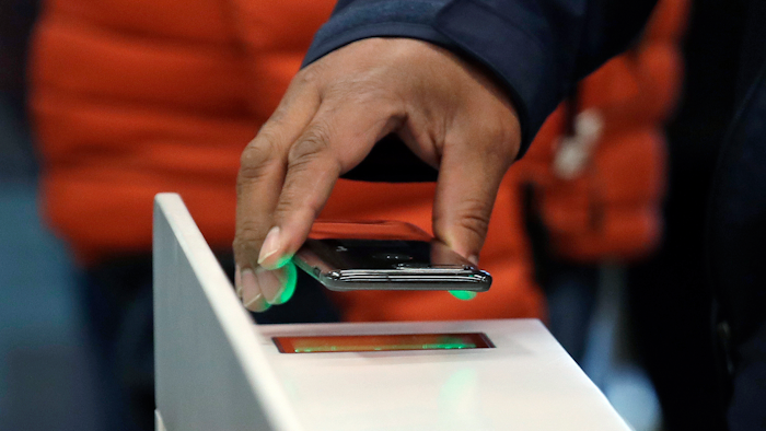 A shopper scans a cellphone app while entering an Amazon Go store in Seattle, Jan. 22, 2018.