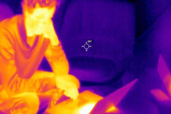 Image showing the difference in thermal radiation and temperature between a person and surfaces.