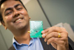 UC-San Diego electrical and computer engineering professor Dinesh Bharadia holds a PCB with a tiny WiFi radio mounted under a black knob.