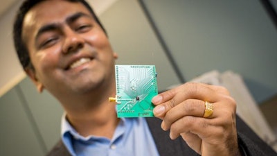 UC-San Diego electrical and computer engineering professor Dinesh Bharadia holds a PCB with a tiny WiFi radio mounted under a black knob.