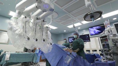 A team prepares to attach a da Vinci robot to a patient while performing a robotic assisted laparoscopic prostatectomy at CHI Memorial Hospital, Nov. 2, 2016, in Chattanooga, Tenn.