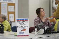 A poll worker speaks with a voter at the Minneapolis Early Voting Center, Jan. 17, 2020.