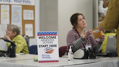 A poll worker speaks with a voter at the Minneapolis Early Voting Center, Jan. 17, 2020.