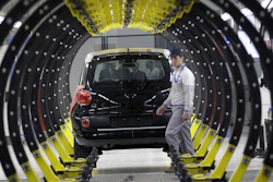 A Fiat factory worker in front of a 500L car, Kragujevac, Serbia, April 16, 2012.