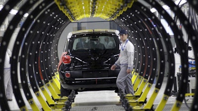 A Fiat factory worker in front of a 500L car, Kragujevac, Serbia, April 16, 2012.