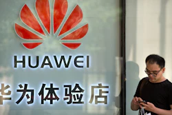 A man uses his smartphone outside of a shop selling Huawei products at a shopping mall in Beijing, May 29, 2019.