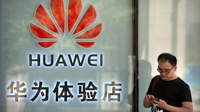 A man uses his smartphone outside of a shop selling Huawei products at a shopping mall in Beijing, May 29, 2019.