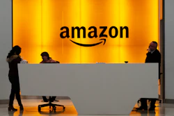 In this Feb. 14, 2019, file photo, people stand in the lobby of Amazon offices in New York.