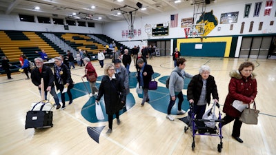 Local residents enter an Iowa Democratic caucus at Hoover High School, Feb. 3, 2020, in Des Moines.