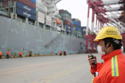 In this Feb. 4, 2020, photo, a foreman wears a face mask at a container port in Qingdao, China.