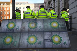 Police officers stand near activists outside BP's headquarters, St James' Square, London, Feb. 5, 2020.