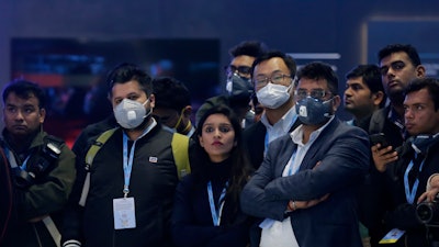 Delegates wear face mask as they attend an event at the Auto Expo in Greater Noida, India, Feb. 5, 2020.