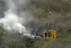 In this Jan. 26, 2020, file photo, firefighters work the scene of a helicopter crash where former NBA star Kobe Bryant died in Calabasas, Calif.
