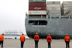 In this Feb. 4, 2020, photo, workers watch a container ship arrive at a port in Qingdao, China.