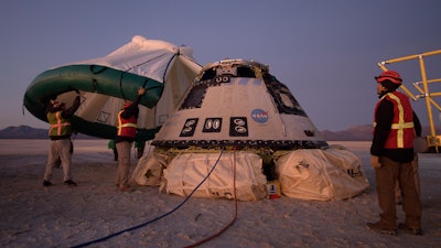 Boeing, NASA and U.S. Army personnel work around the Boeing Starliner spacecraft shortly after it landed in White Sands, N.M., Dec. 22, 2019.